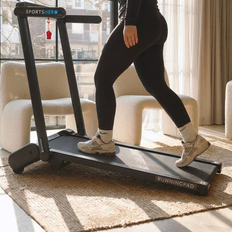 Vrouw wandelt volgens de 12-3-30 methode op een SportsHero RunningPad Pro loopband met helling in de woonkamer